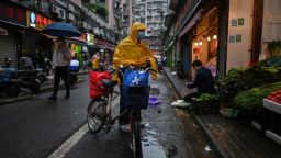 TOPSHOT - A man (C) wearing a face mask arrives to buy vegetables at a stall in Wuhan in China's central Hubei province on April 18, 2020. (Photo by Hector RETAMAL / AFP) (Photo by HECTOR RETAMAL/AFP via Getty Images)
